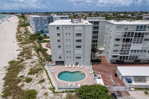 A hotel with a rooftop pool, beach access, and multiple buildings. - Martinique South Unit 306 by SeaBreeze Vacation (Holmes Beach)