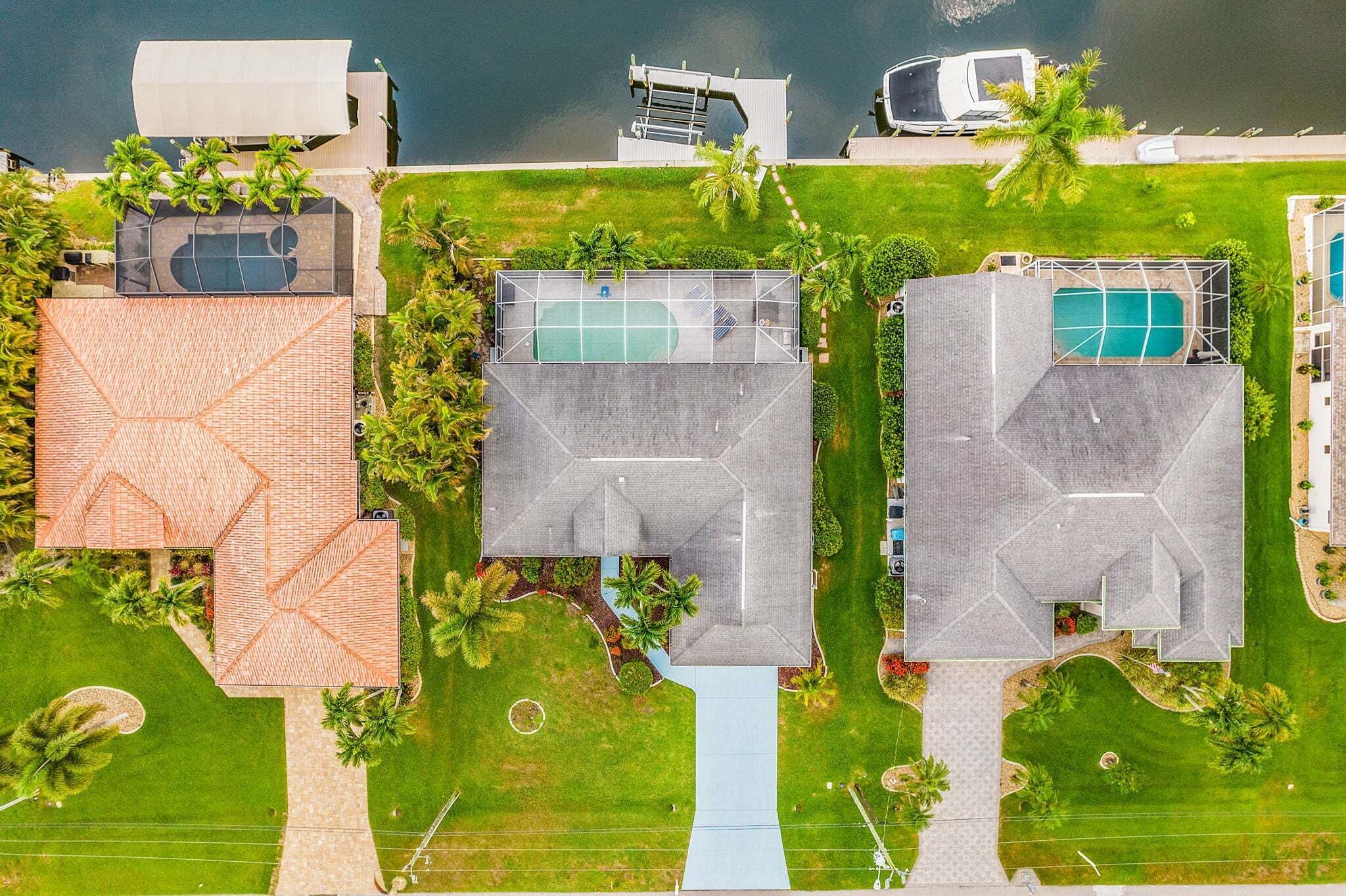 Vue aérienne d’un complexe hôtelier comprenant plusieurs bâtiments, notamment une piscine, un court de tennis et un patio couvert.