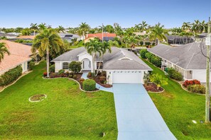 A residential area with houses, palm trees, and a clear sky. - Waterfront Gulf Access Retreat with Heated Pool, Dock & Outdoor Fun - Villa Snowscape - Roelens (Cape Coral)