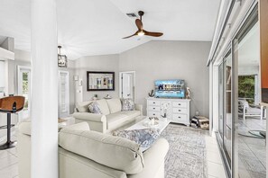 A modern living room with a sofa, coffee table, and a television. - Waterfront Gulf Access Retreat with Heated Pool, Dock & Outdoor Fun - Villa Snowscape - Roelens (Cape Coral)