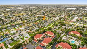 An aerial view of a residential area with houses, streets, and a central landmark. - Waterfront Gulf Access Retreat with Heated Pool, Dock & Outdoor Fun - Villa Snowscape - Roelens (Cape Coral)