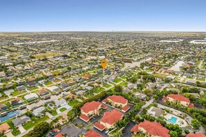 An aerial view of a residential area with houses, streets, and a central landmark. - Waterfront Gulf Access Retreat with Heated Pool, Dock & Outdoor Fun - Villa Snowscape - Roelens (Cape Coral)