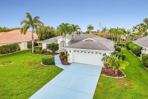 A residential neighborhood with houses, palm trees, and a well-maintained lawn. - Waterfront Gulf Access Retreat with Heated Pool, Dock & Outdoor Fun - Villa Snowscape - Roelens (Cape Coral)