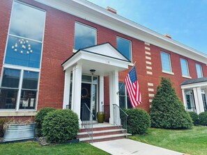 A red brick building with a white porch, an American flag, and a mailbox. - Luxe Bozeman Downtown Fun! (Bozeman)