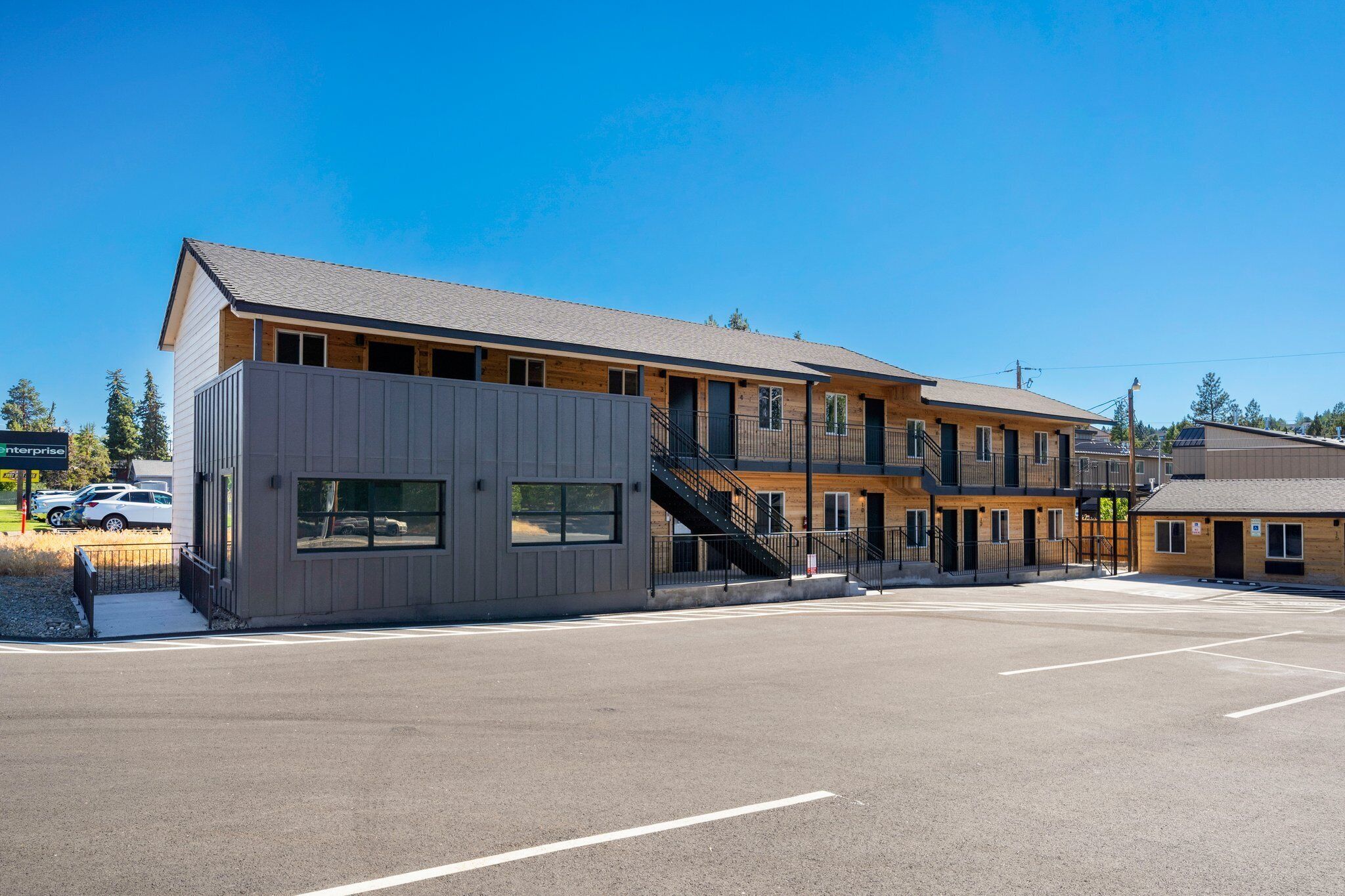 A multi-story building with a parking lot in front.