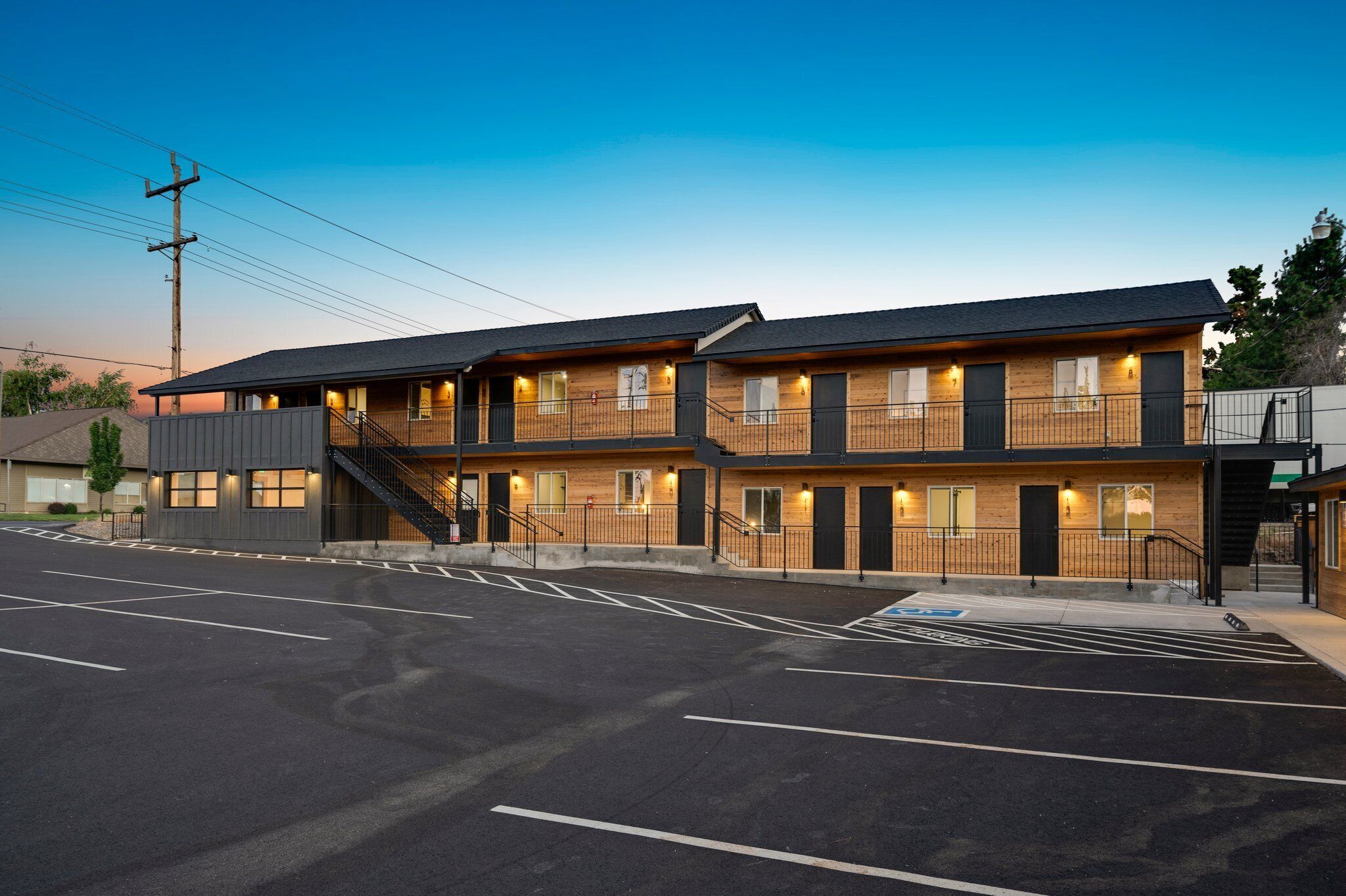 A two-story building with a flat roof, multiple windows, and a staircase leading to the upper level.