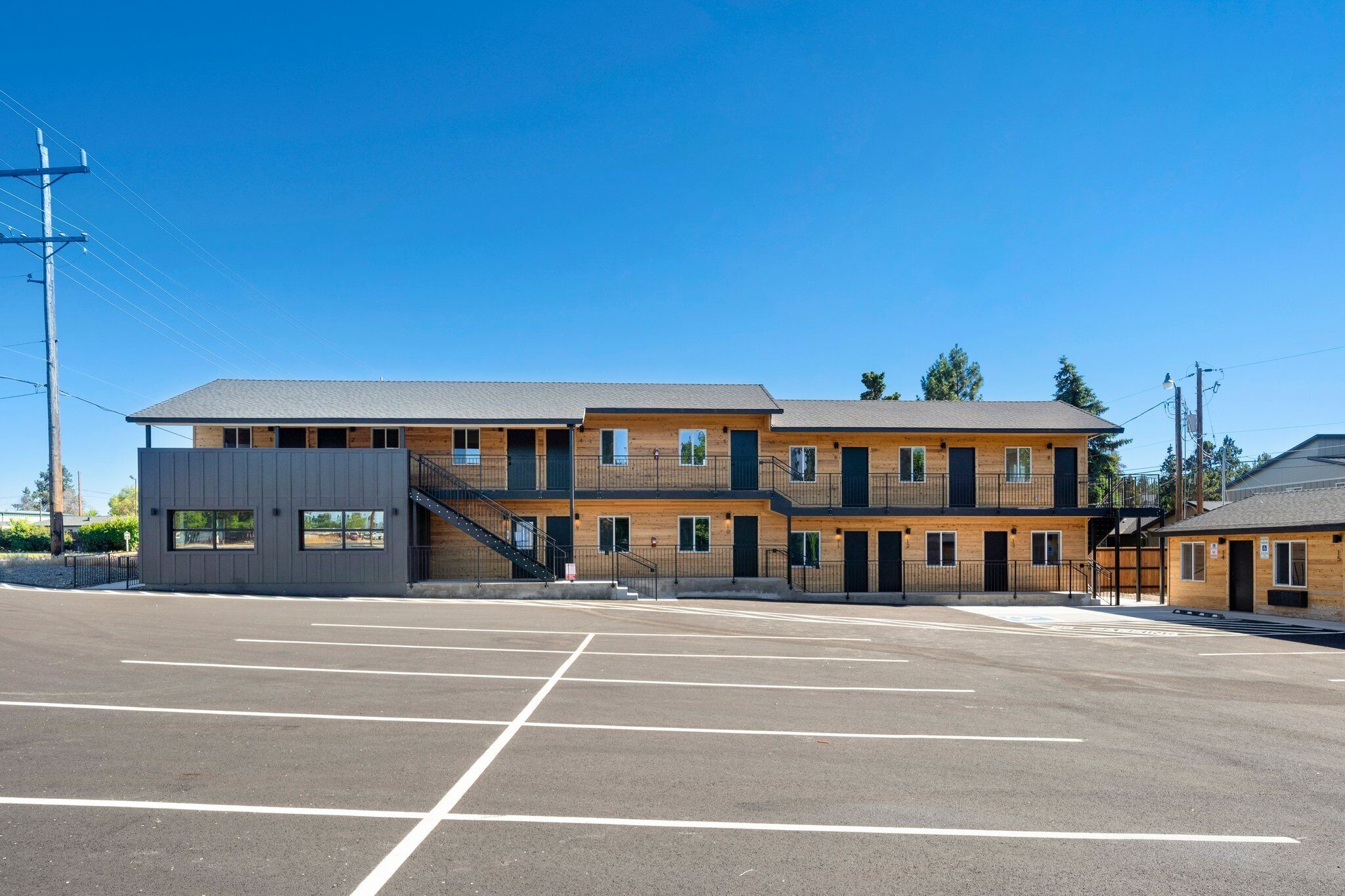 A multi-story building with a parking lot in front.