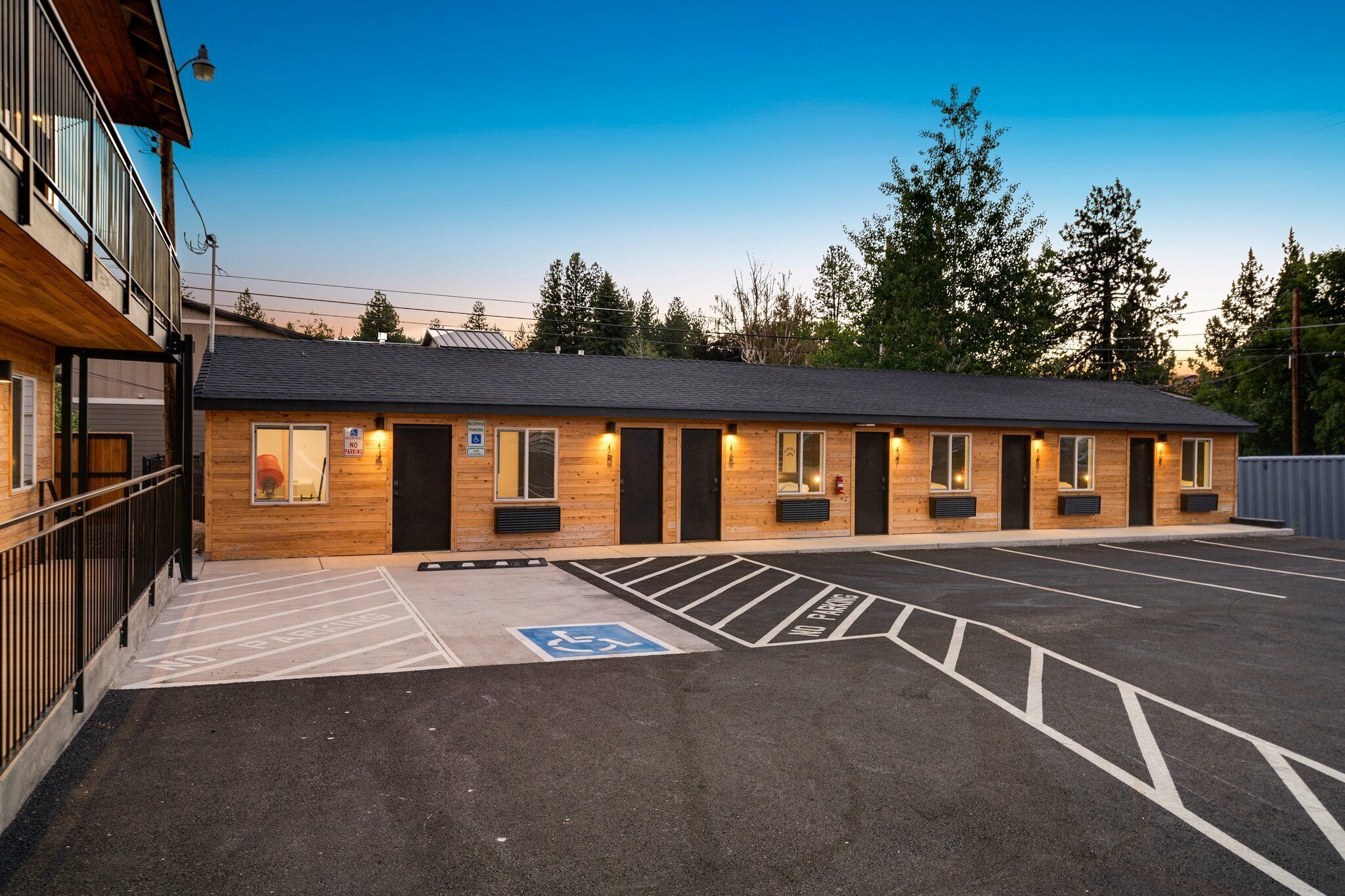 A building with multiple doors and windows, a parking lot with marked spaces, and a wheelchair-accessible area.