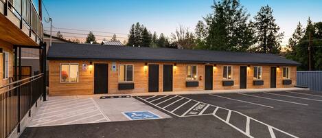 A building with multiple doors and windows, a parking lot with marked spaces, and a wheelchair-accessible area.