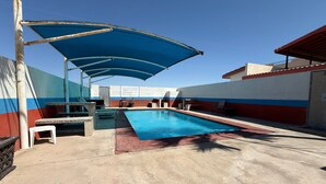 A swimming pool with a blue canopy, a white chair, and a table. - San Felipe Condo w/ Shared Pool & Beach Access - Rancho Bugambilias B (San Felipe)