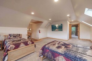 A bedroom with two beds, a painting on the wall, and a skylight. - Golden Oak Estate | 7BR Luxury. Wine Room. Views. (Big Bear Lake)