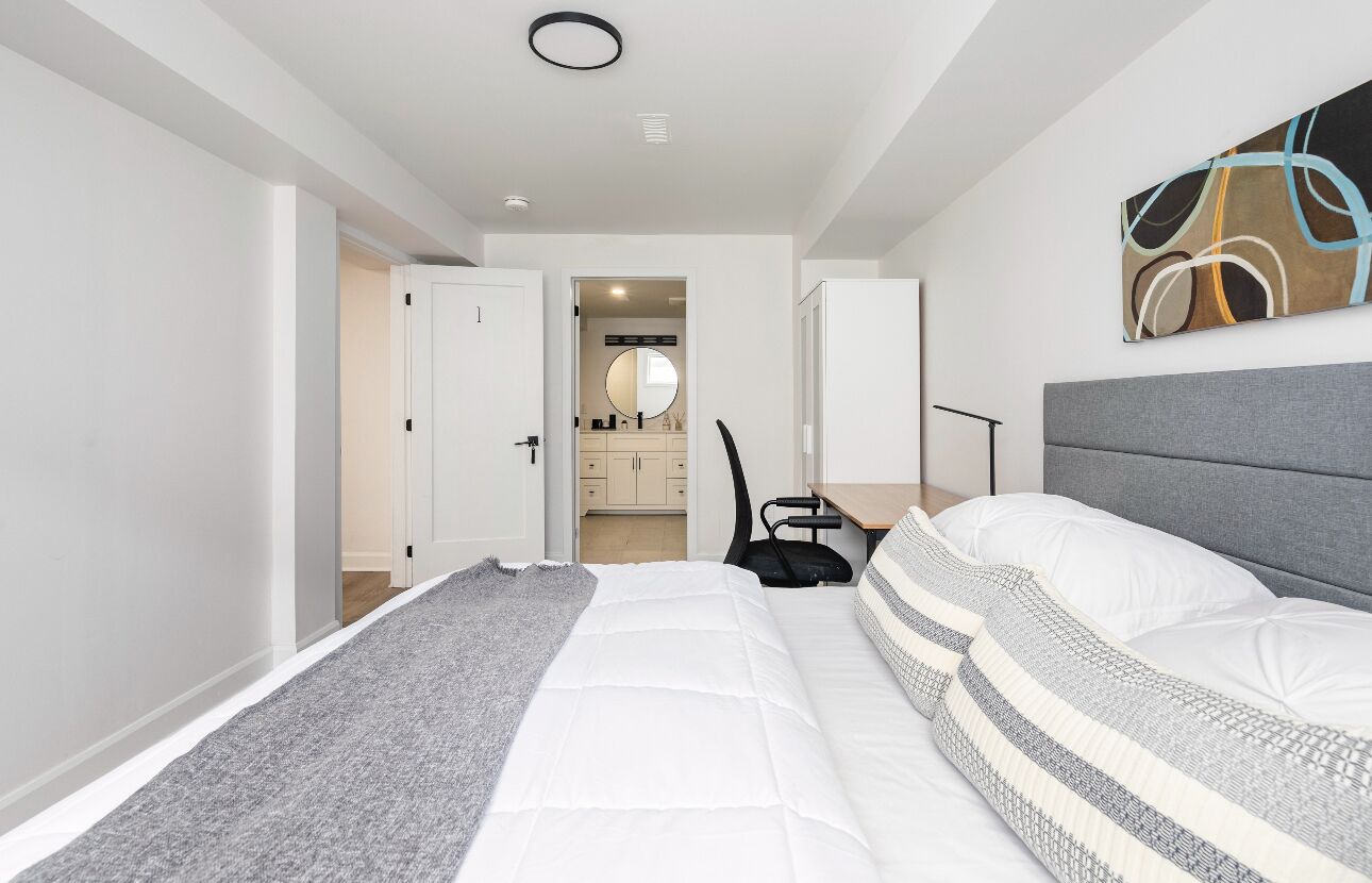 Une chambre moderne avec un grand lit, un bureau et une chaise.