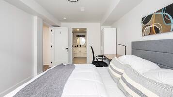 Une chambre moderne avec un grand lit, un bureau et une chaise.
