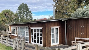 Puinen rakennus, jossa on suuret ikkunat ja puinen aita.
