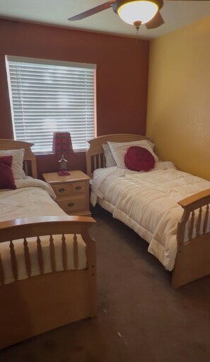 A bedroom with two beds, a nightstand, a lamp, and a ceiling fan. - Beautiful family and pet friendly estate in Temecula Wine Country region (Aguanga)