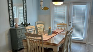 A dining room with a wooden table, six chairs, a dresser, a mirror, and a ceiling light fixture. - 3 Bedroom home with access to the canal! (Supply)