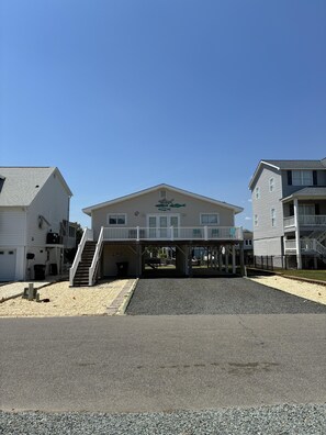 A two-story building with a covered entrance and a staircase leading to a balcony. - 3 Bedroom home with access to the canal! (Supply)
