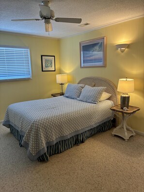 A bedroom with a bed, two bedside tables, a ceiling fan, and wall-mounted lamps. - 3 Bedroom home with access to the canal! (Supply)