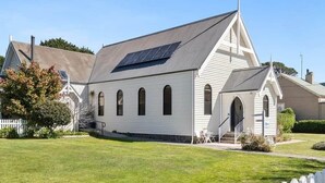A white building with a sloped roof, a solar panel, and a small porch with steps. - Church Conversion @ 39 Hoddle Street (Robertson)