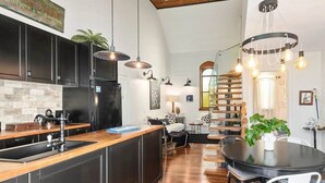 A modern kitchen with a wooden island, black cabinets, and pendant lighting. - Church Conversion @ 39 Hoddle Street (Robertson)