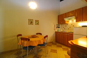 Eine Küche mit Esstisch, Stühlen und einem Kühlschrank.