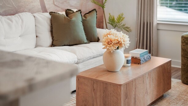 A modern living room with a white sofa, a wooden coffee table, and a vase with flowers. - King Bed + Balcony Walk to Ponce City Market & BeltLine in Atlanta (Atlanta)
