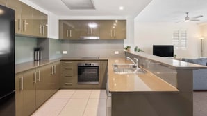Una cocina moderna con una isla central, horno integrado y electrodomésticos de acero inoxidable.