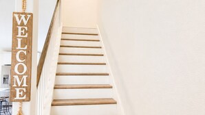 Una escalera de madera con un letrero que dice 'WELCOME' en la pared.