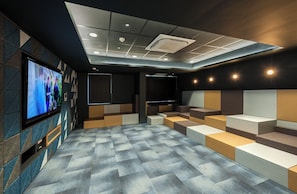 A modern cinema room with a large screen, tiered seating, and a patterned carpet. - Student Only West Village (Glasgow)