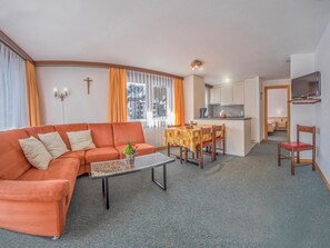 Ein Wohnzimmer mit einer Couch, einem Couchtisch und einem Essbereich mit Tisch und Stühlen.