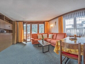 Ein gemütliches Wohnzimmer mit einer Couch, einem Couchtisch und einem Essbereich mit Tisch und Stühlen.