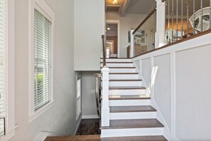 Eine Treppe mit weißen Stufen und dunklen Holellenzäunen, die zu einer Aussichtsplattform führt.