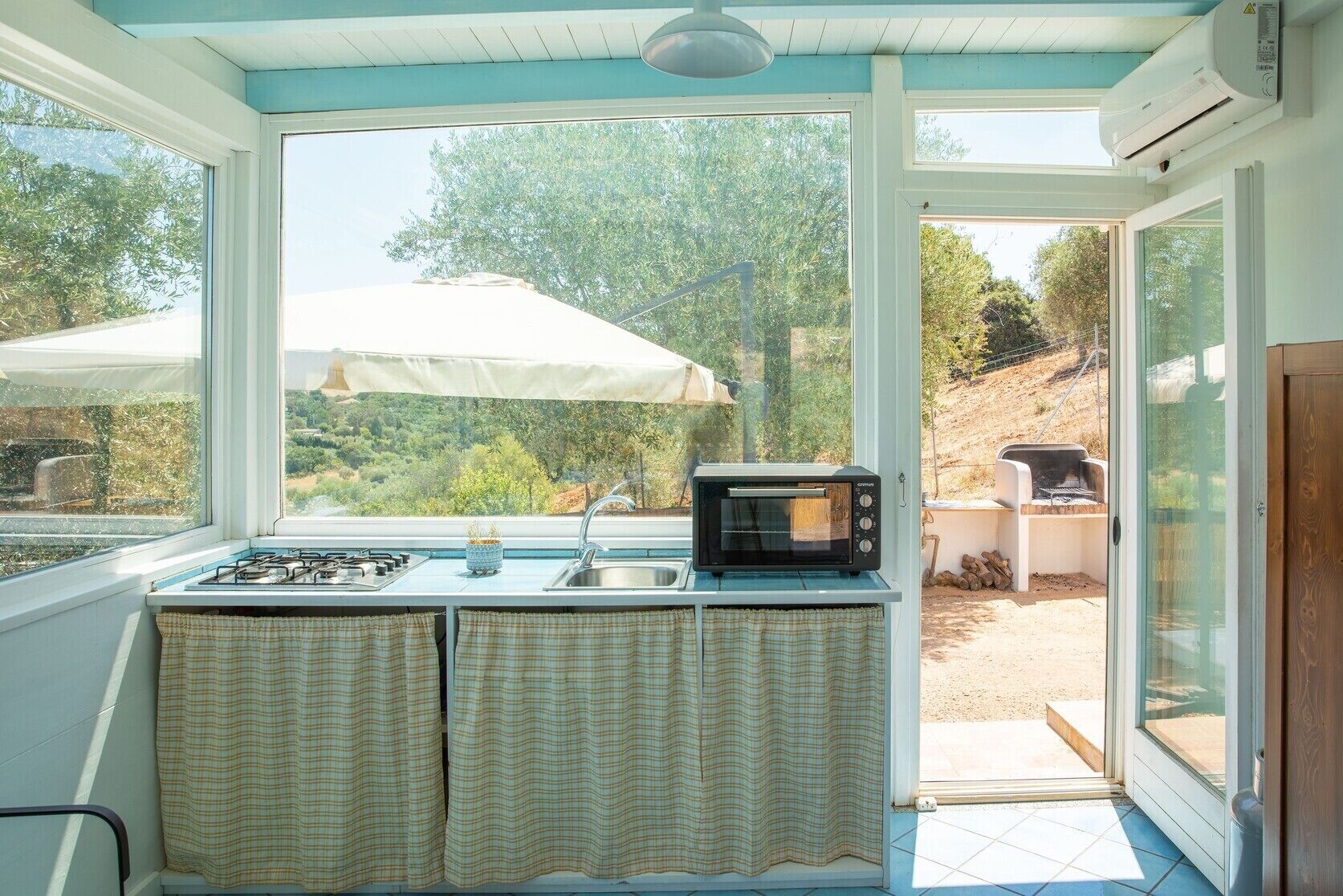 A kitchen with a gas stove, a microwave, and a sink.