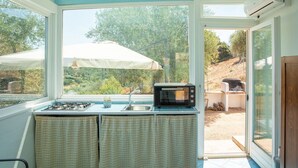 A kitchen with a gas stove, a microwave, and a sink. - Casa Valverde, Alghero (Alghero)