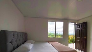 Un dormitorio con cama, ventana y puerta.