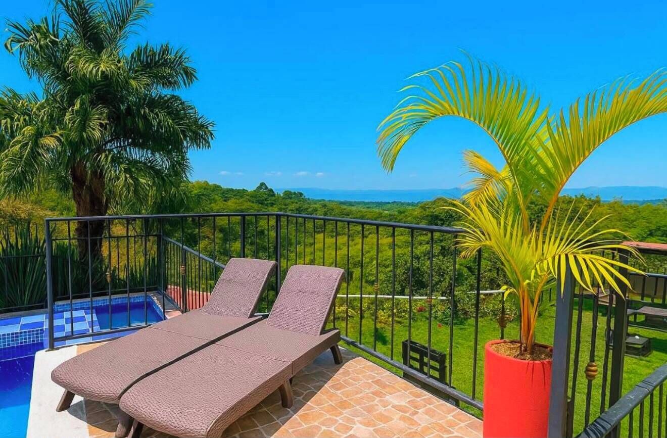 Un balcón con dos sillones de descanso, una pequeña piscina y vistas al paisaje.