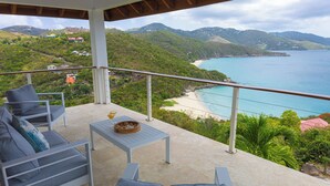 Ein Balkon mit Blick auf Strand und Berge.