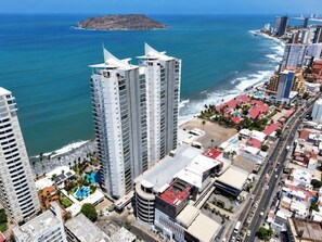Un paisatge urbà costaner amb edificis alts, una platja i una vista clara de l'oceà.