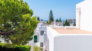 Un edificio costero con paredes blancas, una puerta verde y vista al mar.