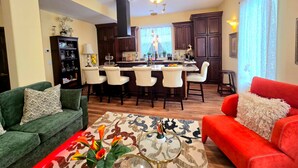 A modern living room with a red sofa, green armchair, and a coffee table with decorative items.