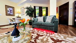 A living room with a sofa, a glass coffee table, a potted plant, and a decorative figurine.