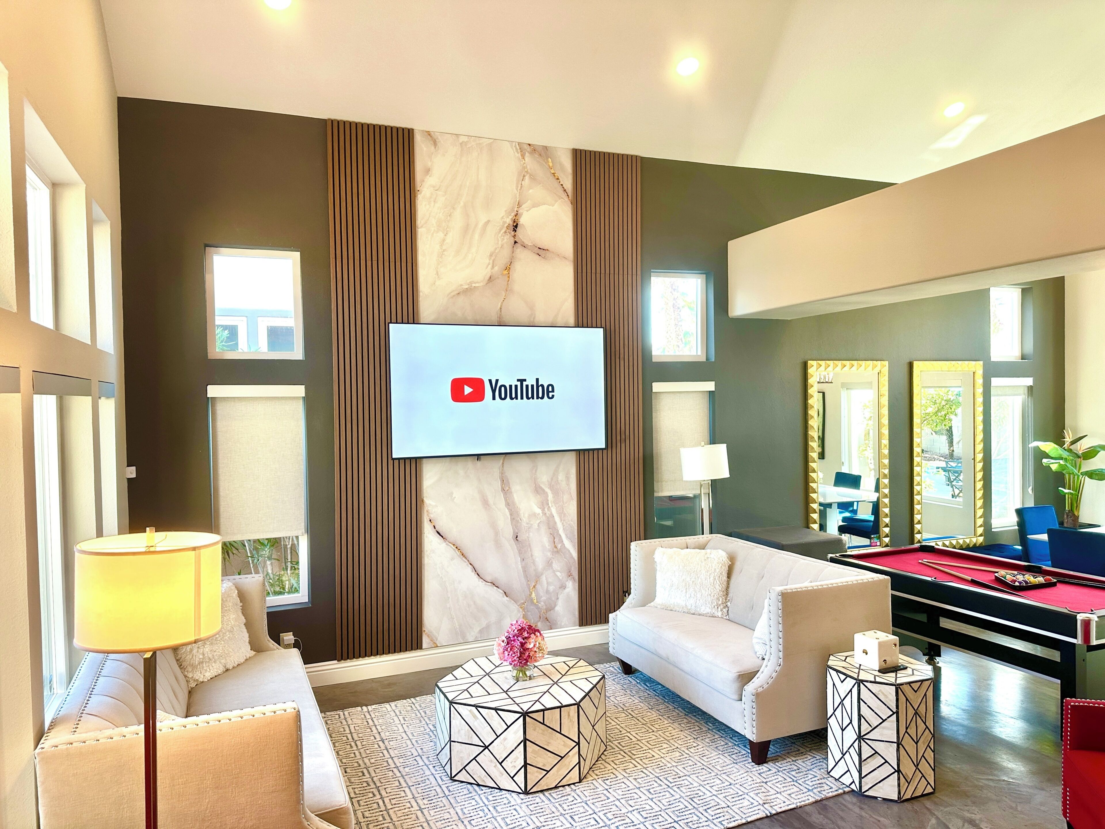 Una sala de estar moderna con sofá, mesa de centro y mesa de billar.