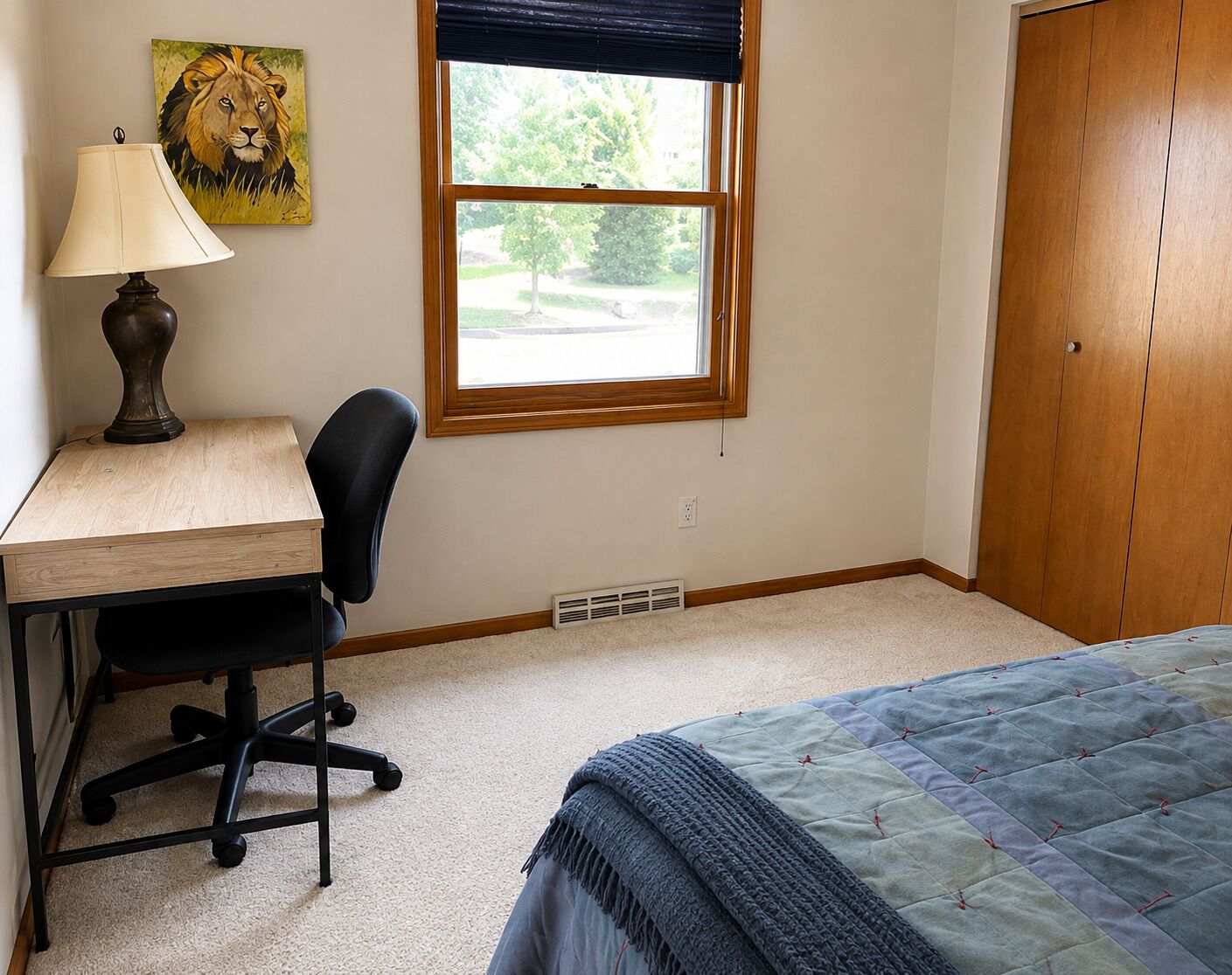 Une chambre à coucher comprenant un bureau, une chaise, un lit, une fenêtre et une porte.