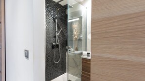 A modern bathroom with a glass shower enclosure, a marble-tiled wall, and a wooden vanity. - Escapade des Marines - Welkeys (Cogolin)