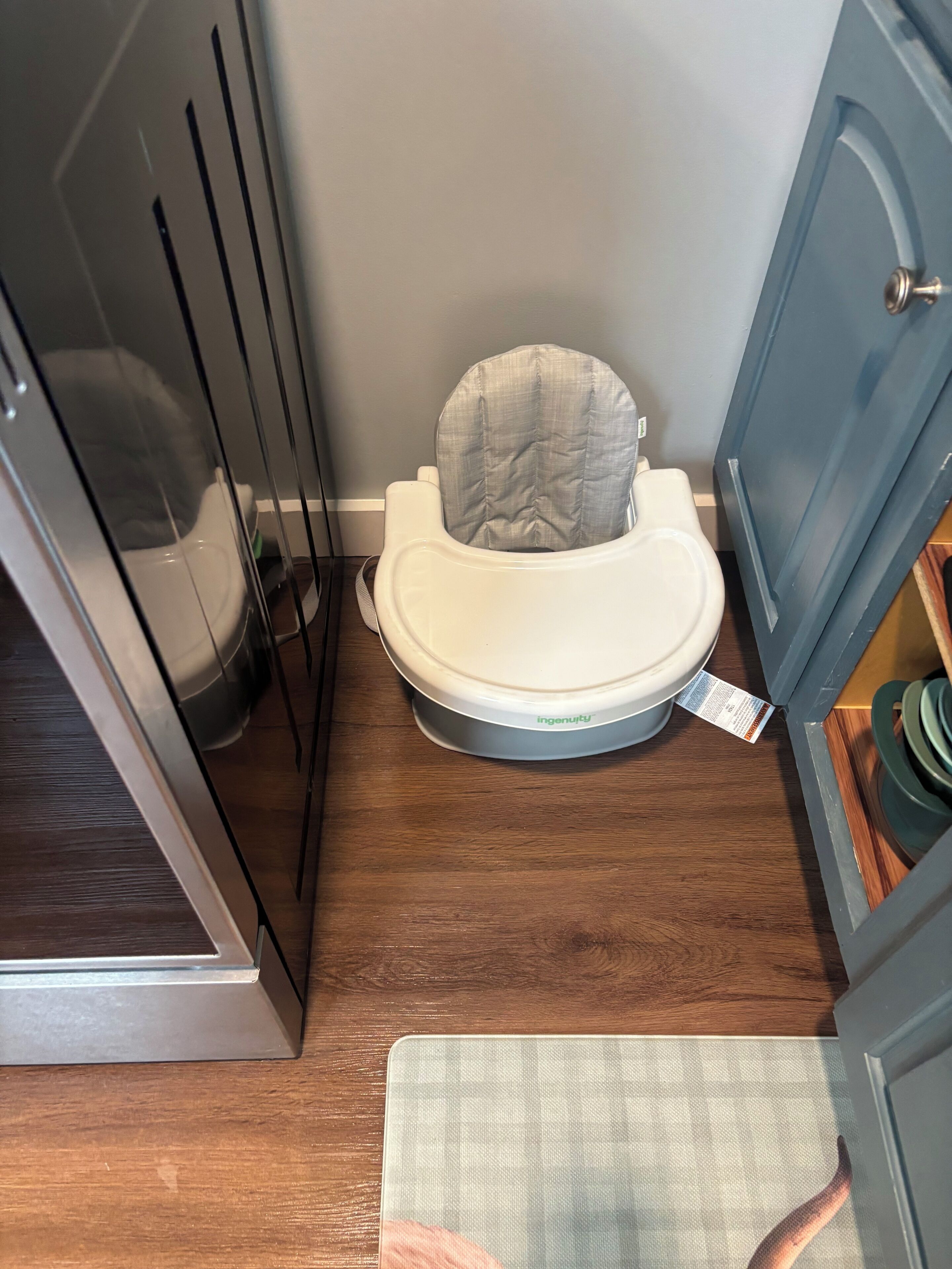 A small bathroom with a toilet, a shower stall, and a cabinet.