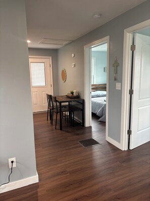 A room with a dining table, chairs, a bed, and a door. - The Arkside Cottage - The ark, creation museum, Williamstown marina (Williamstown)
