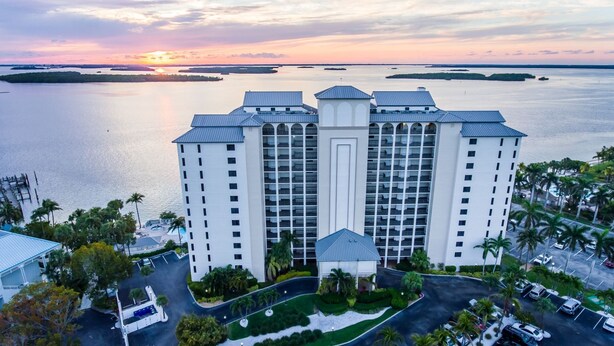 Un hotel di grandi dimensioni con numerosi piani, un cortile centrale e vista sull'acqua circostante.