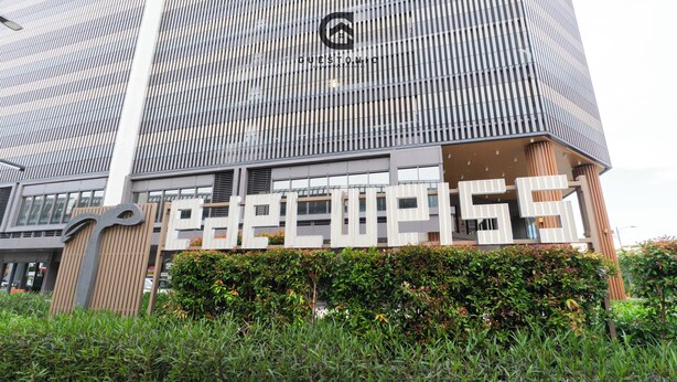 A modern building with a prominent 'GUESTHOUSE' sign, featuring a unique architectural design with vertical lines and a large logo at the top. - Edelweiss Tropicana Gardens by Guestonic (Petaling Jaya)