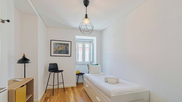 A bedroom with a bed, a desk, a chair, a lamp, and a window. - Blue Coconut Second, By Home Match (Setúbal)