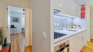 A modern kitchen with a double sink, stainless steel appliances, and a clean, minimalist design. - Blue Coconut Second, By Home Match (Setúbal)